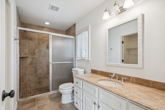 bathroom with vanity, tile patterned floors, a shower with door, and toilet