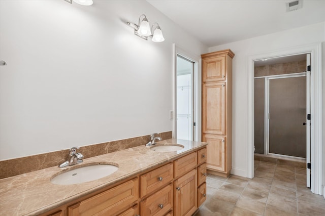 bathroom featuring vanity, a shower with shower door, and tile patterned flooring