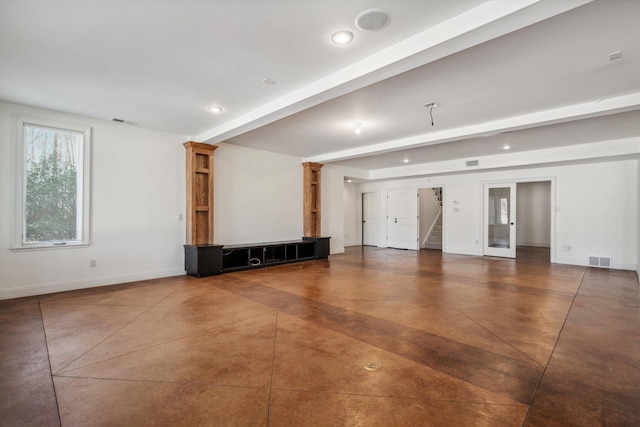 unfurnished living room with beam ceiling