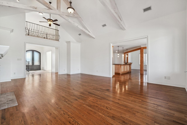 unfurnished living room with high vaulted ceiling, beamed ceiling, ceiling fan, dark wood-type flooring, and french doors