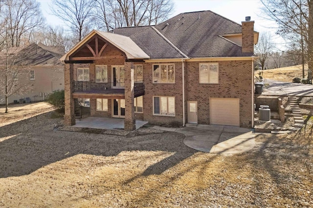 view of front of house featuring cooling unit, a garage, a patio, and a balcony