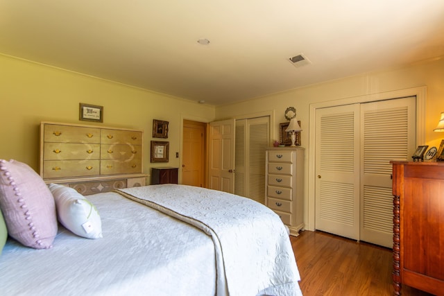 bedroom featuring multiple closets and hardwood / wood-style floors