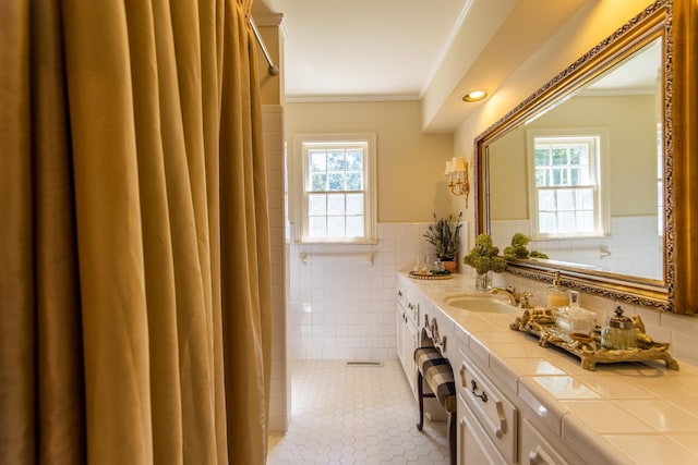 bathroom with crown molding, plenty of natural light, tile patterned flooring, and tile walls