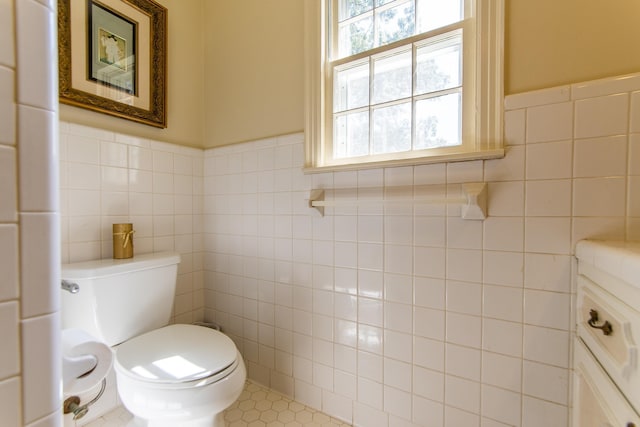 bathroom with vanity, tile walls, and toilet