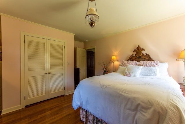 bedroom featuring ornamental molding, dark wood-type flooring, and a closet