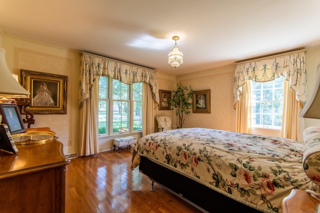 bedroom with crown molding, wood-type flooring, and multiple windows