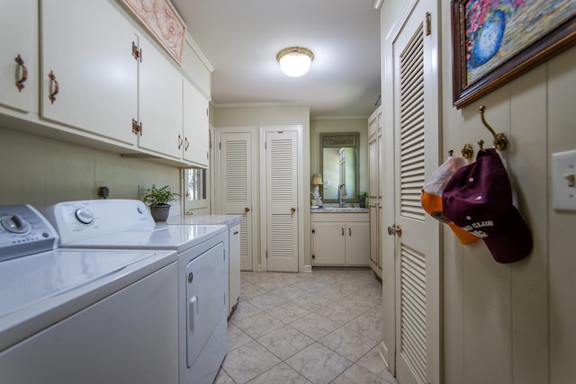 washroom with cabinets, washing machine and dryer, sink, and ornamental molding