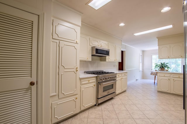 kitchen featuring crown molding, appliances with stainless steel finishes, light tile patterned floors, and backsplash