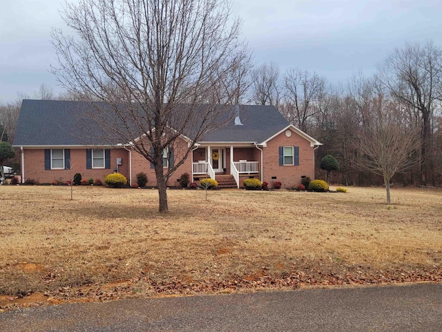 single story home with covered porch and a front yard