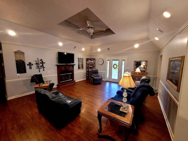 living room with vaulted ceiling, dark hardwood / wood-style flooring, ceiling fan, a raised ceiling, and crown molding