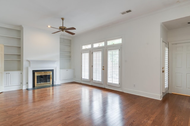 unfurnished living room with visible vents, a fireplace with flush hearth, ornamental molding, wood finished floors, and baseboards