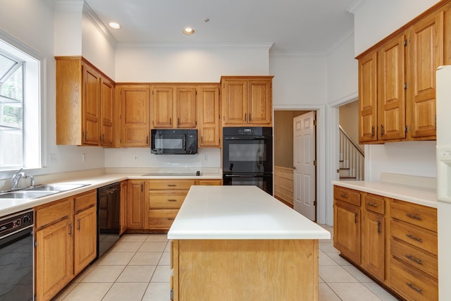 kitchen with brown cabinetry, light countertops, a kitchen island, and black appliances