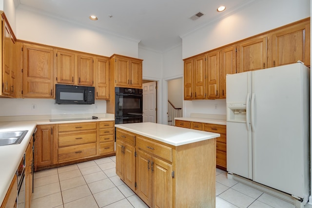 kitchen featuring black appliances, light tile patterned flooring, light countertops, and a center island