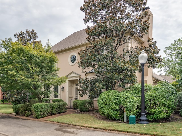 view of front of property featuring a front lawn and stucco siding