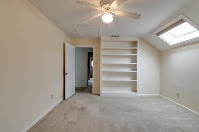 unfurnished bedroom with baseboards, lofted ceiling, attic access, and light colored carpet