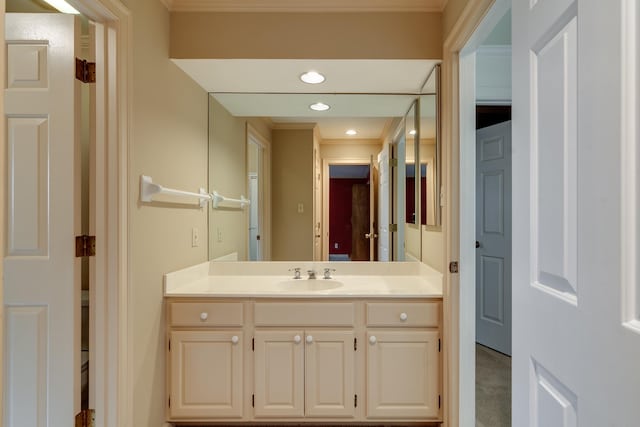 bathroom featuring recessed lighting, ornamental molding, and vanity