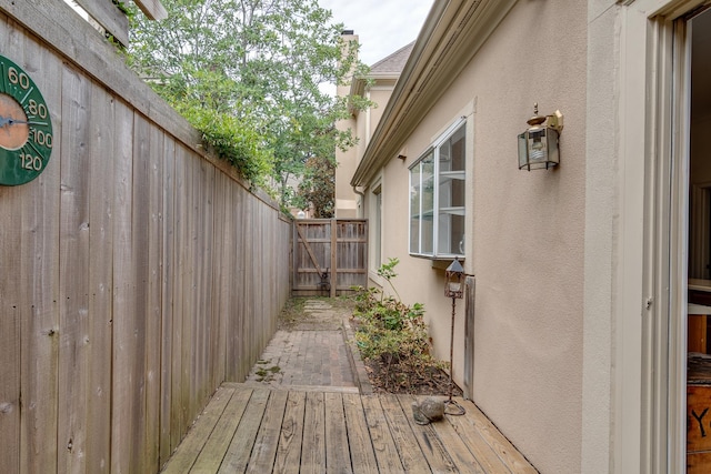 view of side of home featuring fence and stucco siding