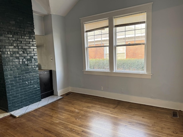 unfurnished living room featuring vaulted ceiling and hardwood / wood-style floors