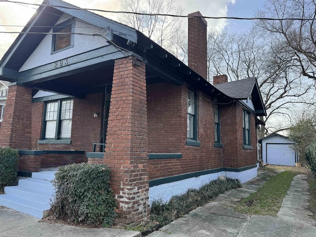 view of side of home featuring a garage and an outbuilding