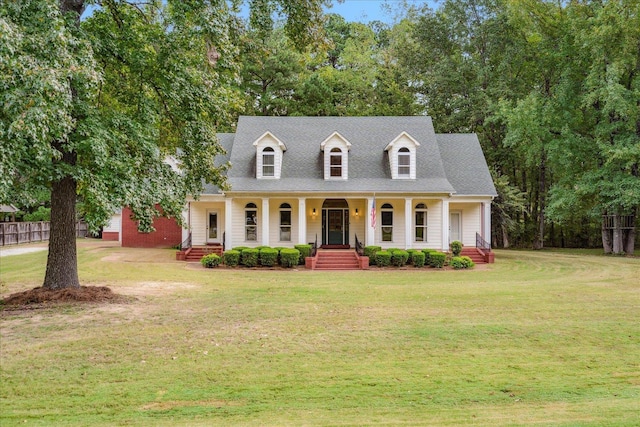 new england style home featuring a front yard and covered porch