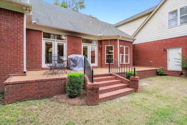 entrance to property featuring a patio and a lawn