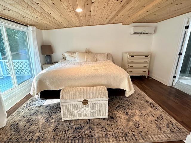 bedroom with an AC wall unit, dark hardwood / wood-style floors, access to outside, and wooden ceiling