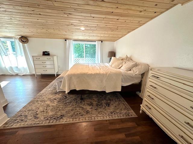 bedroom featuring lofted ceiling, dark hardwood / wood-style floors, multiple windows, and wooden ceiling