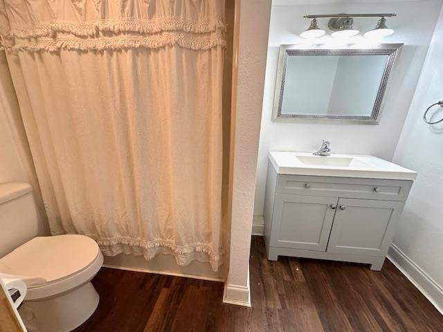 full bathroom with hardwood / wood-style flooring, vanity, toilet, and shower / bath combo