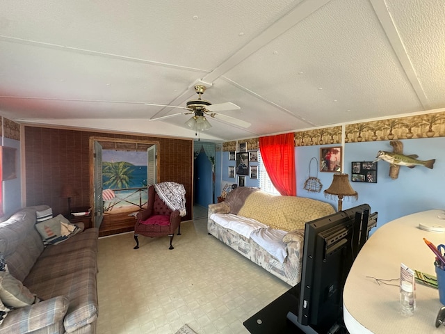 living room with ceiling fan, a textured ceiling, and vaulted ceiling with beams