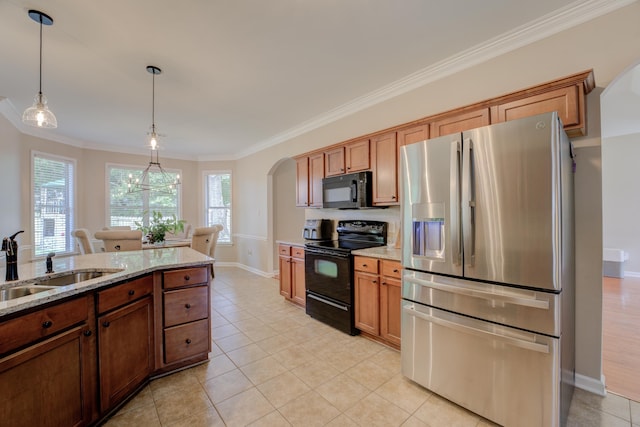 kitchen featuring sink, decorative light fixtures, plenty of natural light, light stone countertops, and black appliances