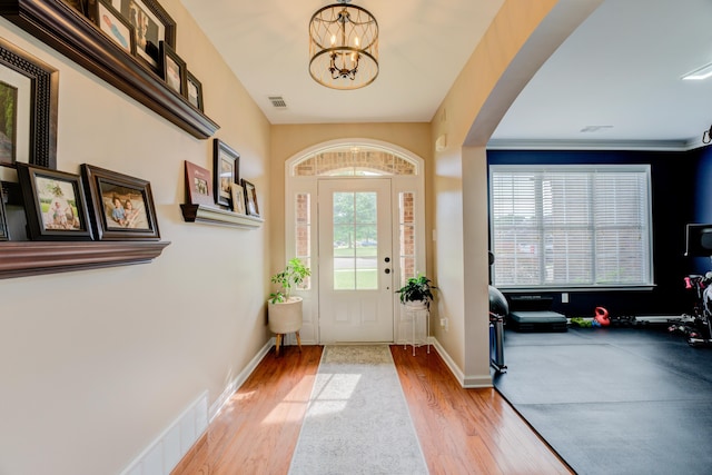 foyer entrance with a chandelier and light hardwood / wood-style flooring