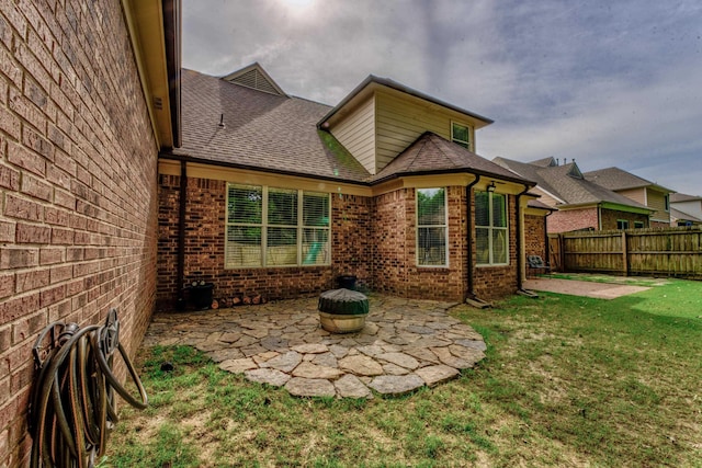 back of property featuring a patio and a yard