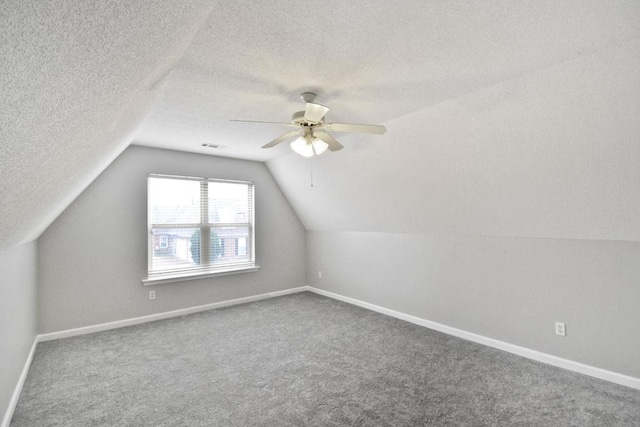 bonus room featuring vaulted ceiling, ceiling fan, carpet floors, and a textured ceiling