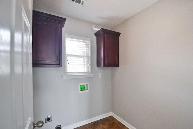 laundry area with cabinets, washer hookup, hookup for an electric dryer, and dark tile patterned floors