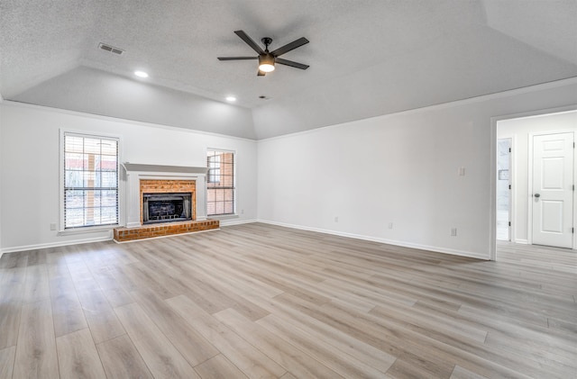 unfurnished living room with light wood-type flooring, vaulted ceiling, ceiling fan, and plenty of natural light