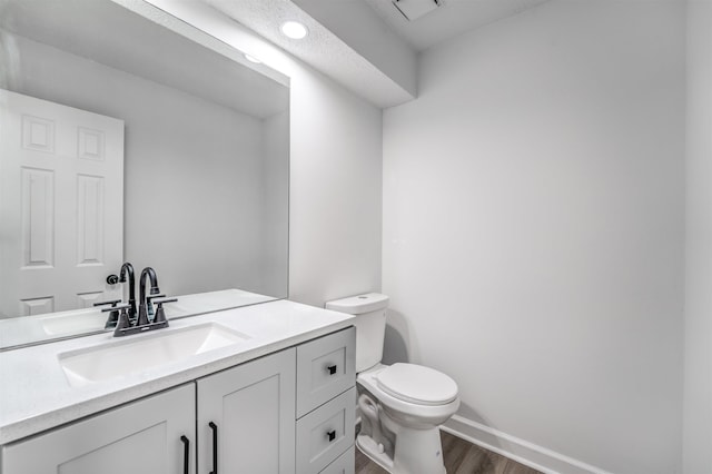 bathroom featuring hardwood / wood-style flooring, vanity, and toilet