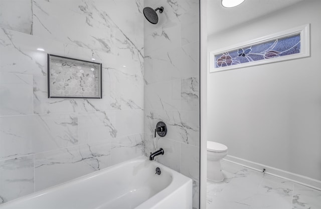 bathroom featuring tiled shower / bath and toilet