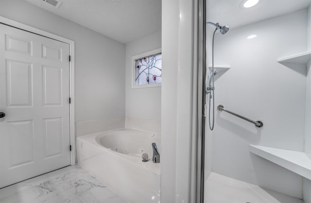 bathroom featuring a bath and a textured ceiling