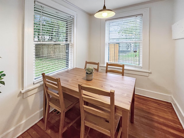 dining space with crown molding and dark hardwood / wood-style flooring