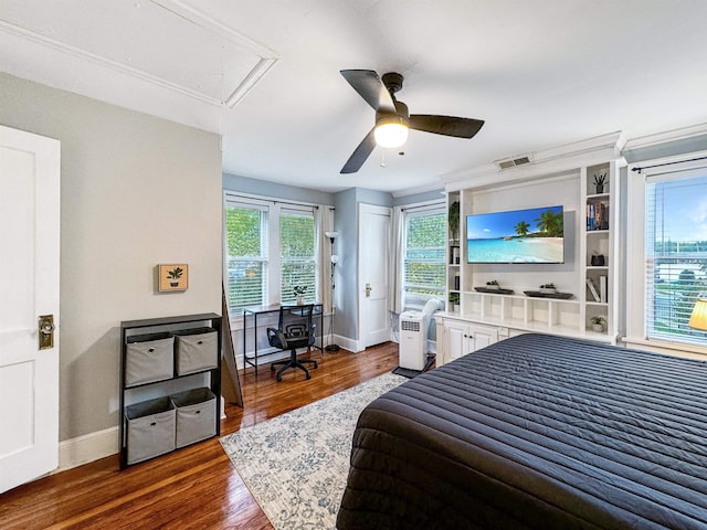 bedroom featuring multiple windows, dark wood-type flooring, and ceiling fan