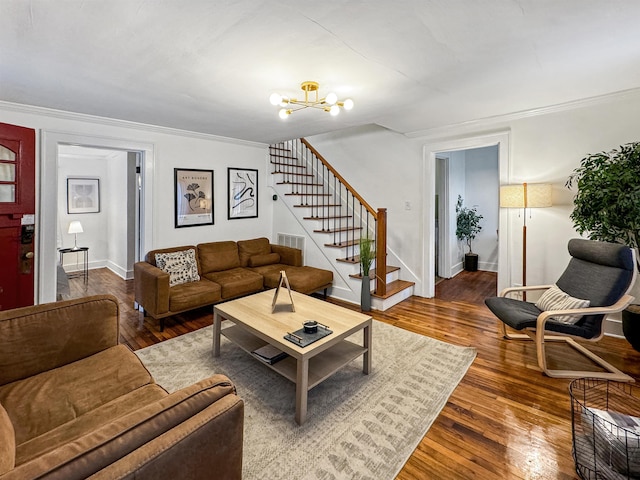 living room featuring dark hardwood / wood-style flooring, a notable chandelier, and crown molding