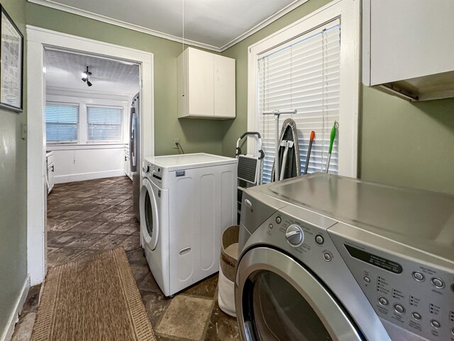 clothes washing area with cabinets, ornamental molding, and separate washer and dryer