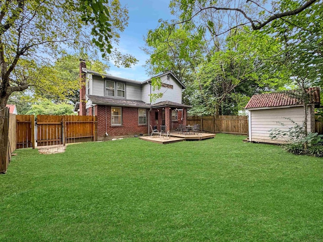 rear view of house with a wooden deck, a yard, and a shed