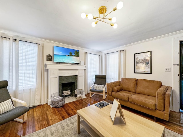 living room featuring hardwood / wood-style flooring, a fireplace, crown molding, and a wealth of natural light