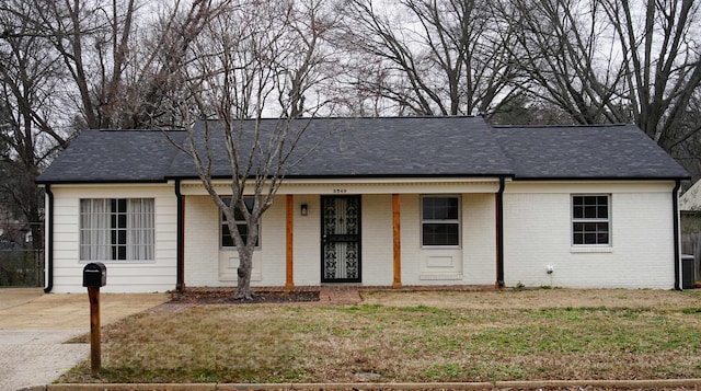 ranch-style house featuring covered porch and a front yard