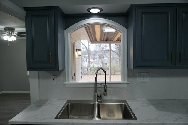 kitchen featuring ceiling fan, light stone countertops, sink, and backsplash