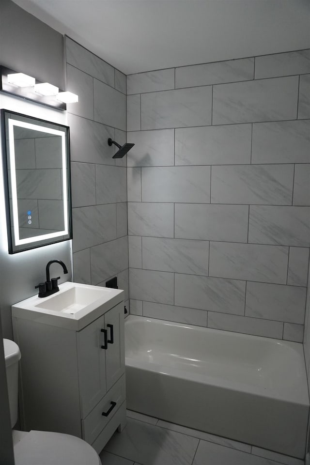 full bathroom with tiled shower / bath, vanity, and toilet