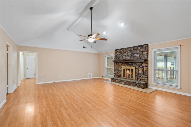 unfurnished living room with lofted ceiling with beams, visible vents, a fireplace, and light wood finished floors