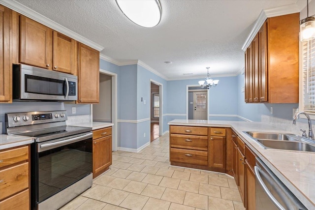 kitchen featuring sink, hanging light fixtures, ornamental molding, stainless steel appliances, and a textured ceiling