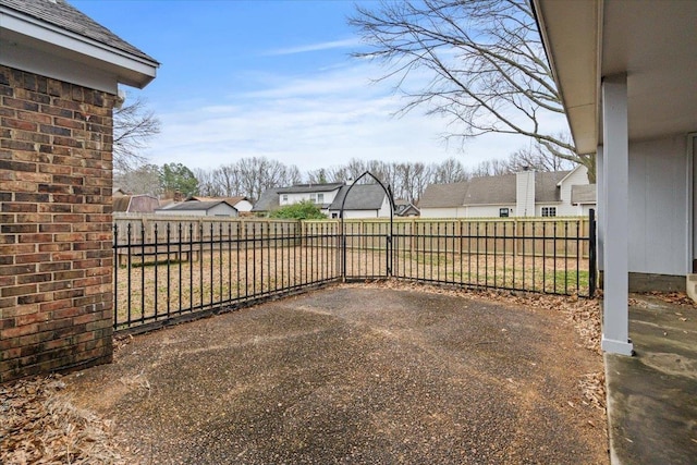 view of yard featuring a patio area, a fenced backyard, and a residential view